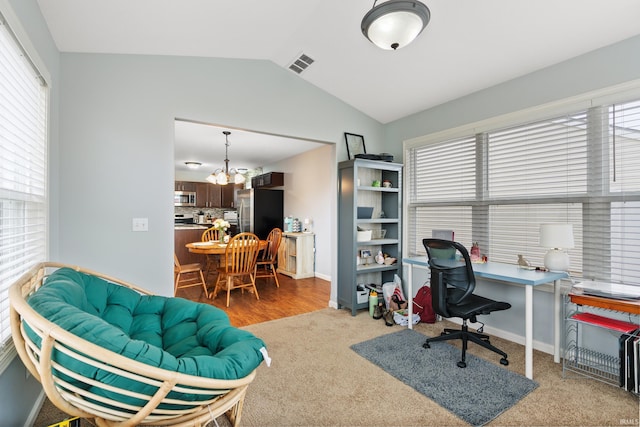 carpeted home office featuring lofted ceiling, visible vents, baseboards, and an inviting chandelier