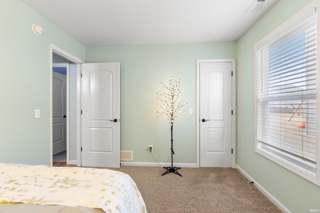 carpeted bedroom with visible vents and baseboards