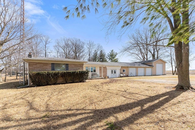 ranch-style home featuring a garage, dirt driveway, a chimney, and brick siding