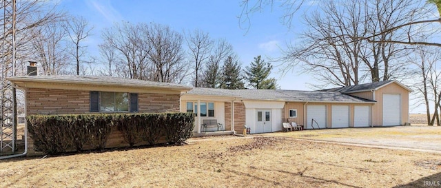 view of front facade featuring a garage, driveway, and a chimney