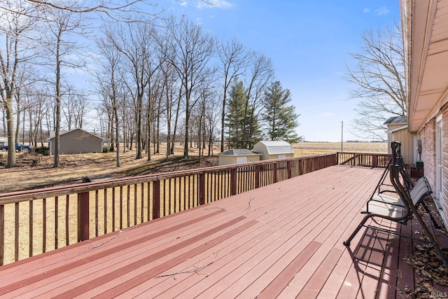 wooden terrace with a storage unit and an outdoor structure