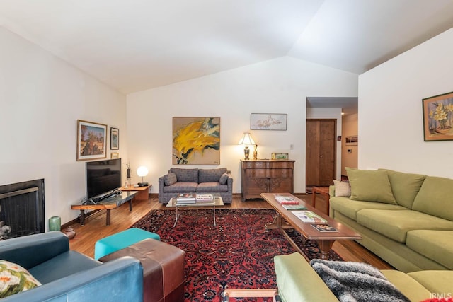 living area with lofted ceiling and wood finished floors