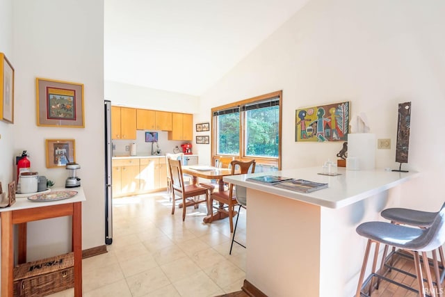 interior space featuring high vaulted ceiling and light tile patterned flooring