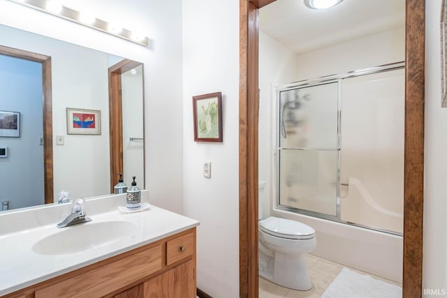 full bathroom with combined bath / shower with glass door, vanity, toilet, and tile patterned floors