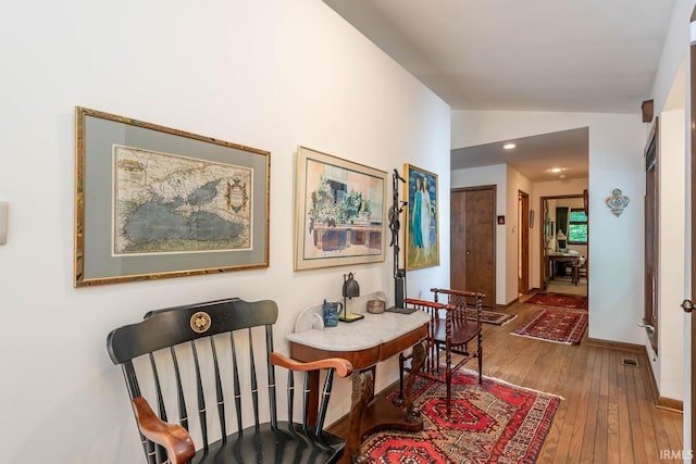 hallway featuring recessed lighting, vaulted ceiling, baseboards, and hardwood / wood-style flooring