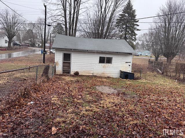 view of outdoor structure featuring fence and central AC