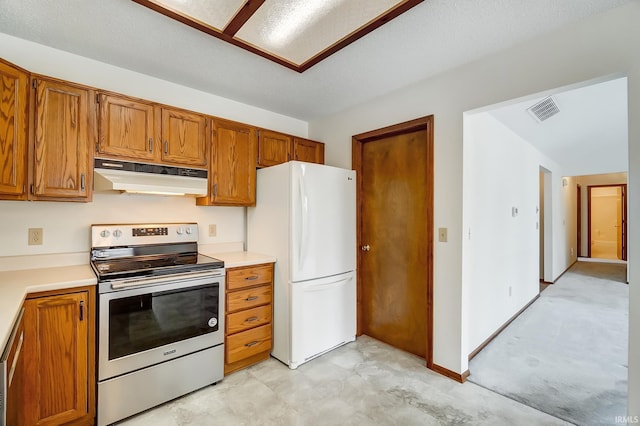 kitchen with electric stove, light countertops, visible vents, freestanding refrigerator, and under cabinet range hood