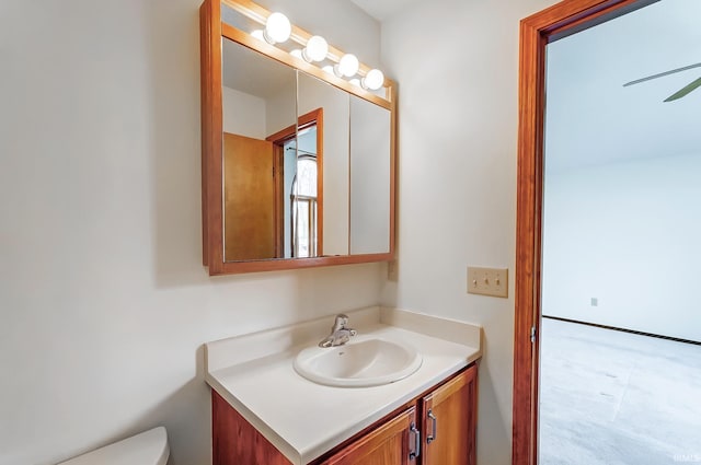 bathroom with toilet, ceiling fan, and vanity