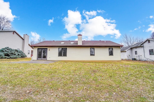 back of house with a patio area, a yard, a chimney, and central AC unit