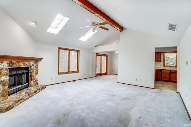 unfurnished living room with a fireplace, a sink, visible vents, baseboards, and beamed ceiling