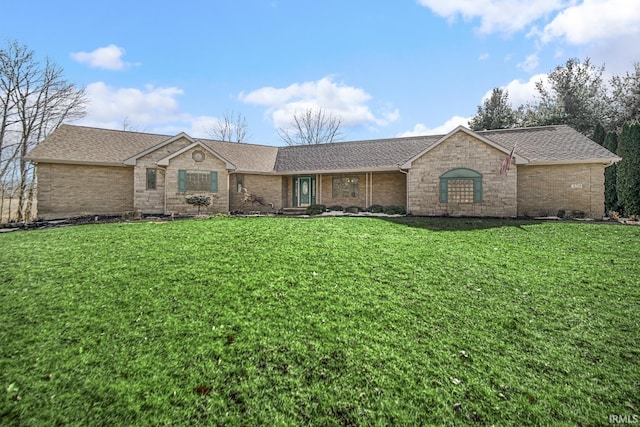 view of front of house featuring brick siding, a front lawn, and a shingled roof