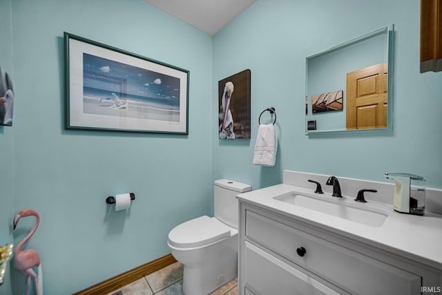 half bath with toilet, vanity, and tile patterned flooring