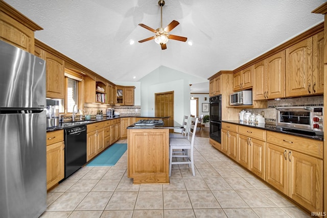 kitchen featuring dark countertops, a kitchen island, vaulted ceiling, light tile patterned flooring, and black appliances