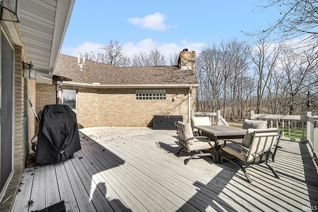 wooden deck with outdoor dining area and a grill