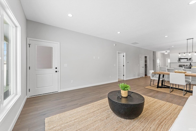 living room featuring recessed lighting, plenty of natural light, and light wood-style flooring