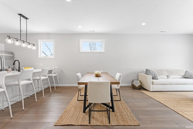 dining room featuring baseboards, wood finished floors, and recessed lighting