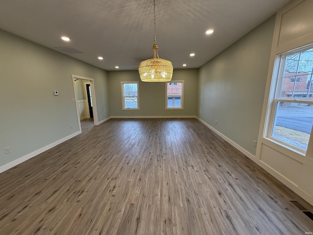 unfurnished dining area with baseboards, wood finished floors, and recessed lighting