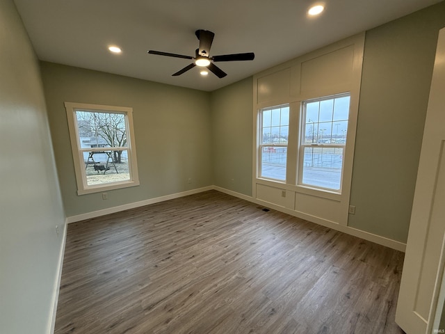 spare room with recessed lighting, wood finished floors, a ceiling fan, visible vents, and baseboards