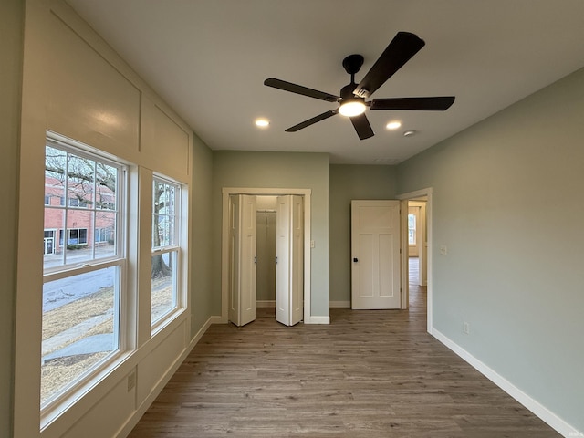 unfurnished bedroom with recessed lighting, ceiling fan, baseboards, and wood finished floors