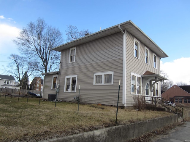 view of home's exterior with central air condition unit, fence, and a lawn