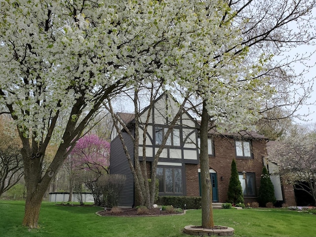 view of front of house featuring brick siding and a front lawn