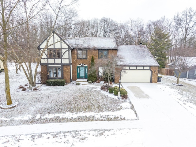 tudor house with french doors, brick siding, and an attached garage