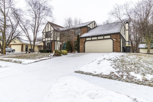 tudor home featuring brick siding, a chimney, and an attached garage