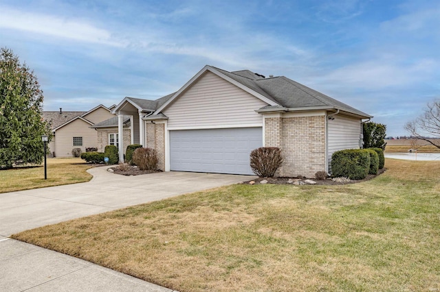 single story home featuring a garage, a front yard, brick siding, and driveway