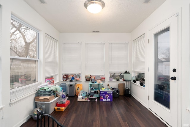 recreation room with a textured ceiling, wood finished floors, and visible vents