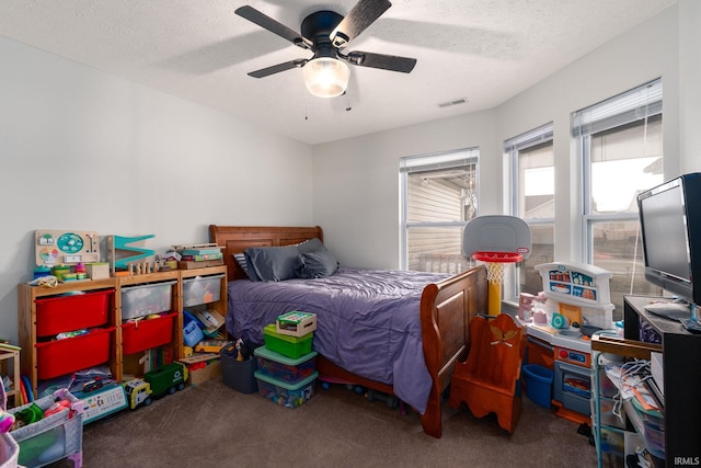 bedroom featuring ceiling fan, a textured ceiling, visible vents, and carpet flooring