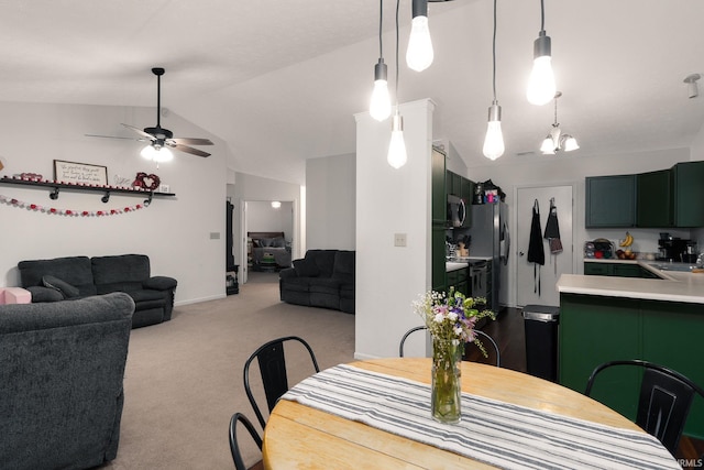 dining space featuring carpet floors, vaulted ceiling, and ceiling fan with notable chandelier