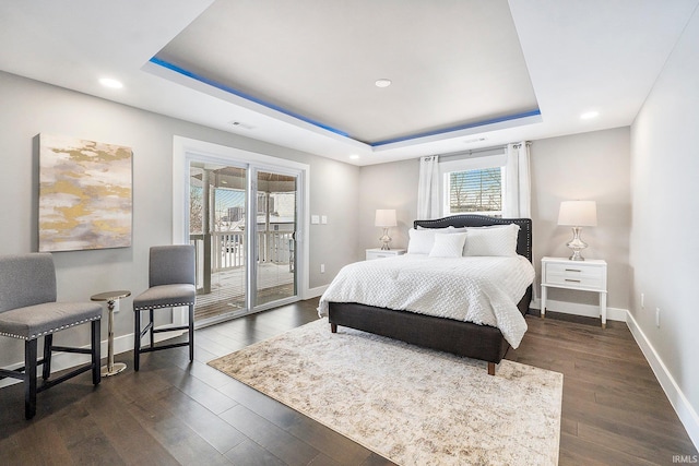 bedroom with visible vents, baseboards, dark wood finished floors, access to exterior, and a raised ceiling