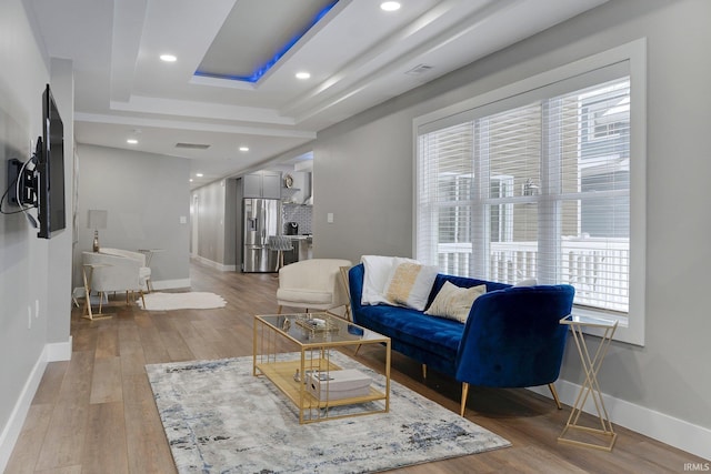 living area featuring light wood-style flooring, visible vents, baseboards, and recessed lighting