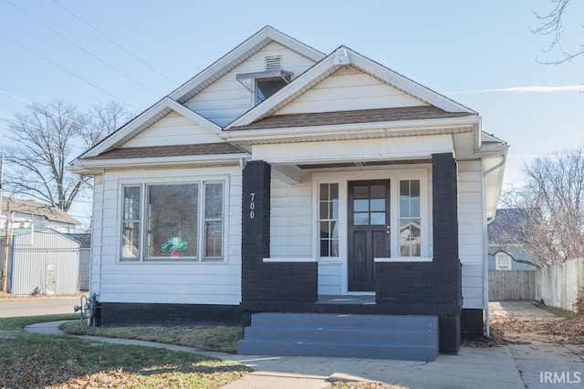 bungalow with roof with shingles and fence