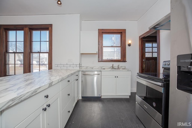 kitchen with light stone counters, dark wood-style floors, appliances with stainless steel finishes, white cabinets, and a sink