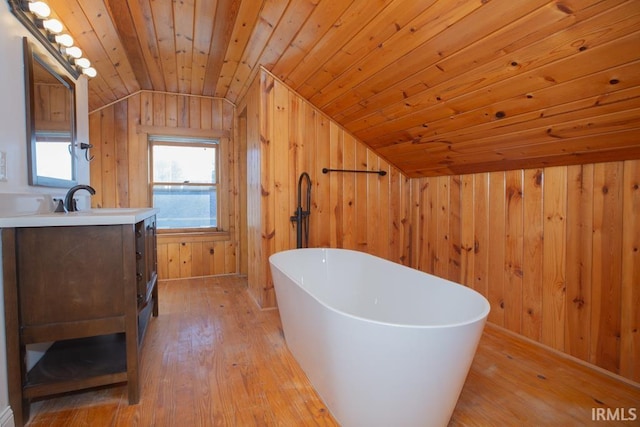 full bath featuring wood walls, a soaking tub, and hardwood / wood-style flooring