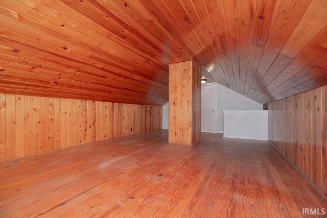 bonus room with lofted ceiling, wooden ceiling, wood walls, and hardwood / wood-style flooring