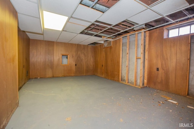 below grade area with a paneled ceiling and wooden walls