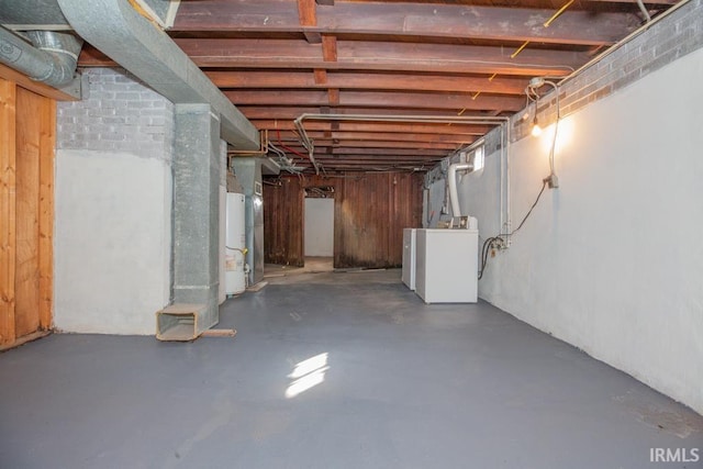 unfinished basement featuring water heater and washing machine and clothes dryer