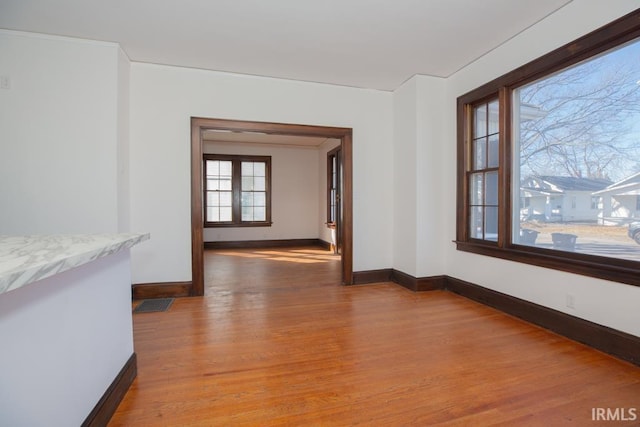 interior space with light wood finished floors, visible vents, and baseboards