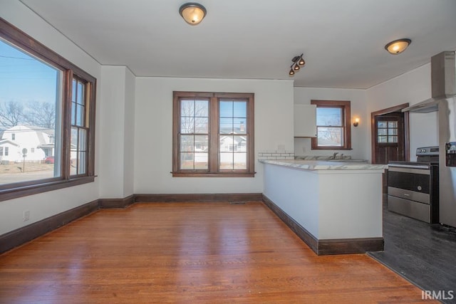 kitchen with stainless steel range with electric stovetop, white cabinetry, dark wood-style floors, and light countertops