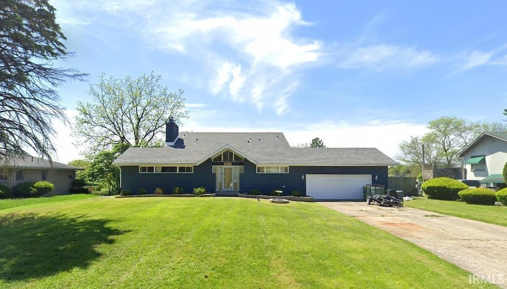 single story home with a garage, concrete driveway, a chimney, and a front lawn