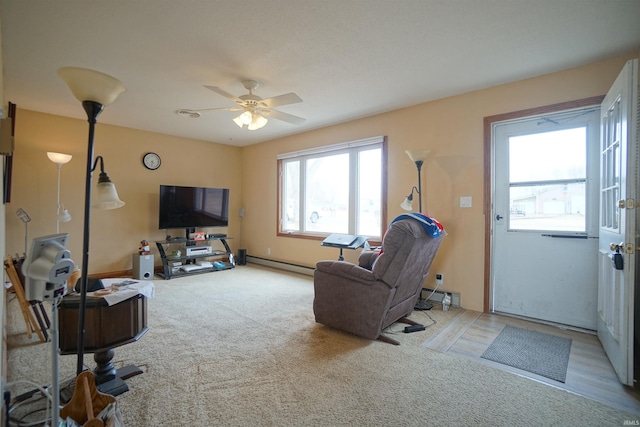 living area with a baseboard radiator, ceiling fan, and carpet