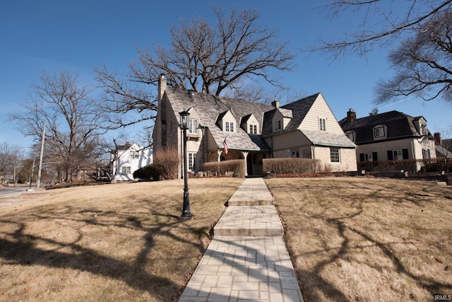 view of front of house with a chimney and a front lawn