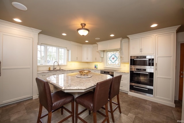 kitchen featuring white cabinetry, a kitchen breakfast bar, a sink, and recessed lighting