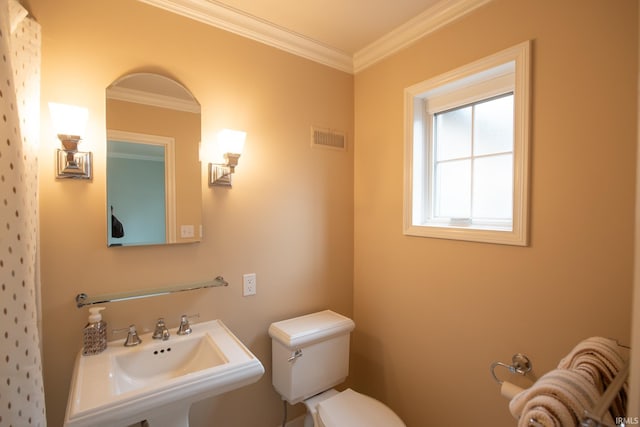 bathroom featuring toilet, a sink, visible vents, and crown molding