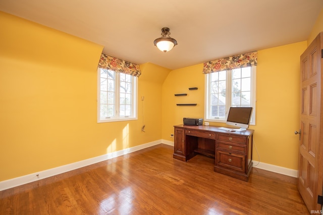 unfurnished office featuring dark wood-style flooring, a wealth of natural light, and baseboards