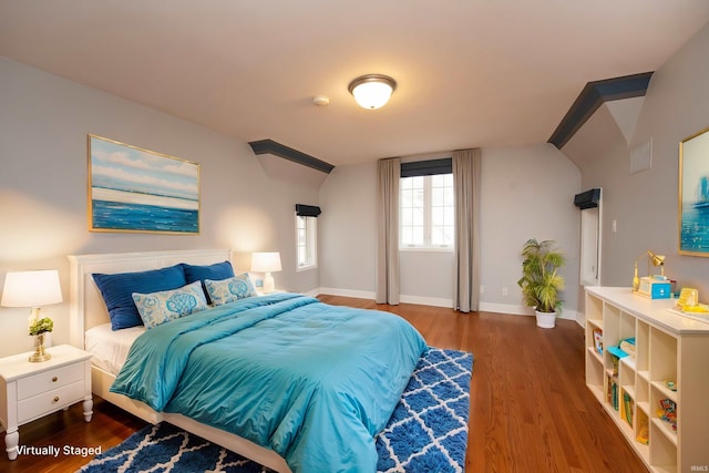 bedroom featuring vaulted ceiling, wood finished floors, and baseboards