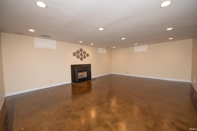 finished below grade area featuring recessed lighting, baseboards, visible vents, and a multi sided fireplace