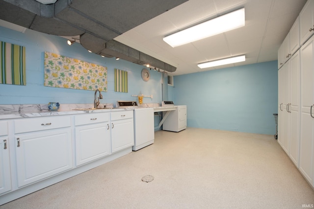 kitchen with white cabinetry, washer / clothes dryer, and a sink